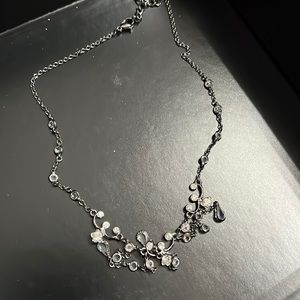 Black with clear stones necklace hangs right below neckline